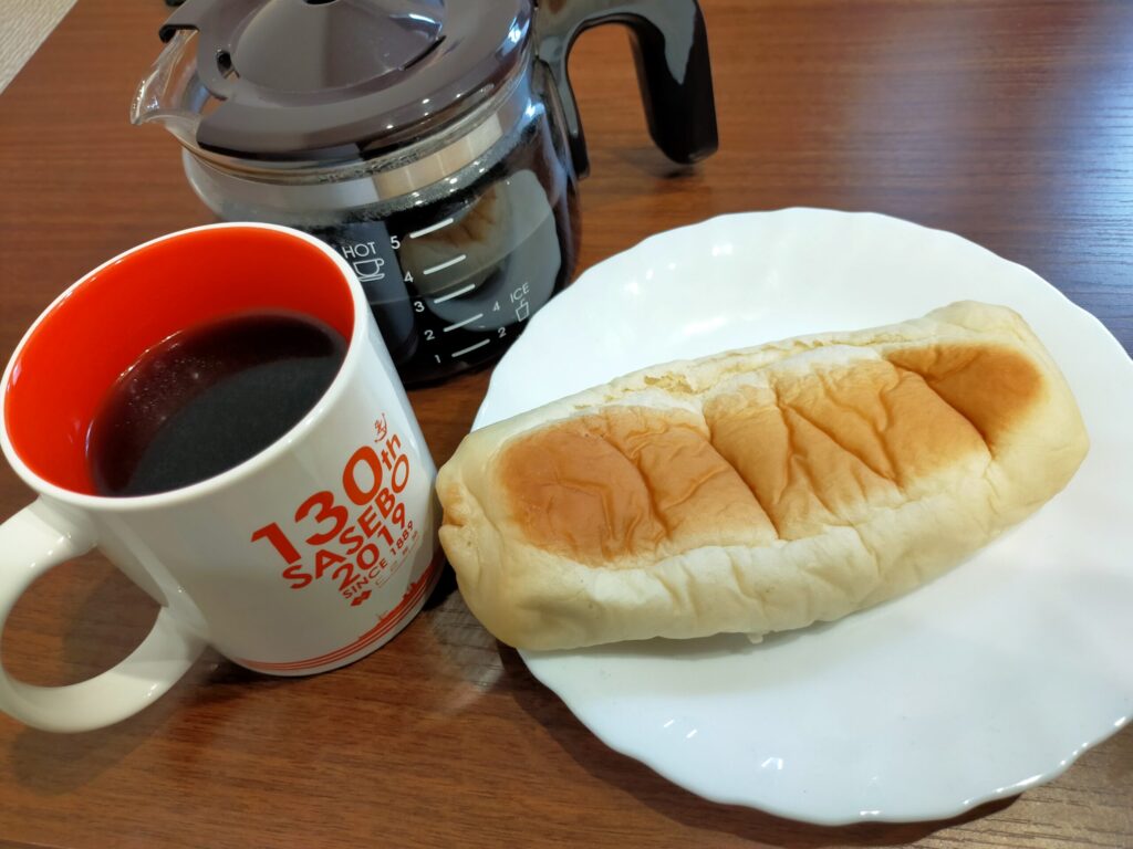 美味しそうなコーヒーとリョーユーパンのもちもち明太チーズが並んでいる