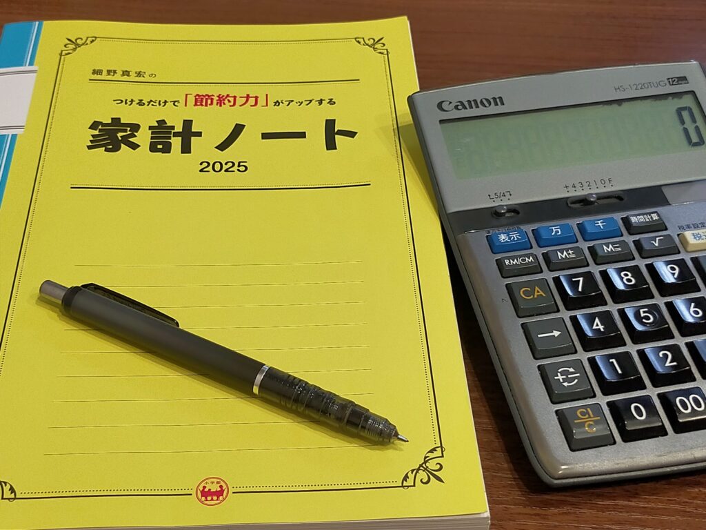 家計ノートとシャーペン、電卓が並んでいる