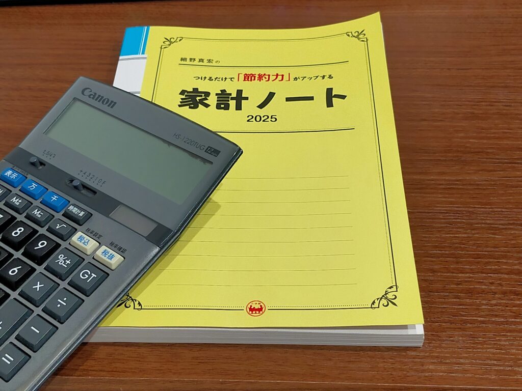 家計ノートと電卓が並んでいる